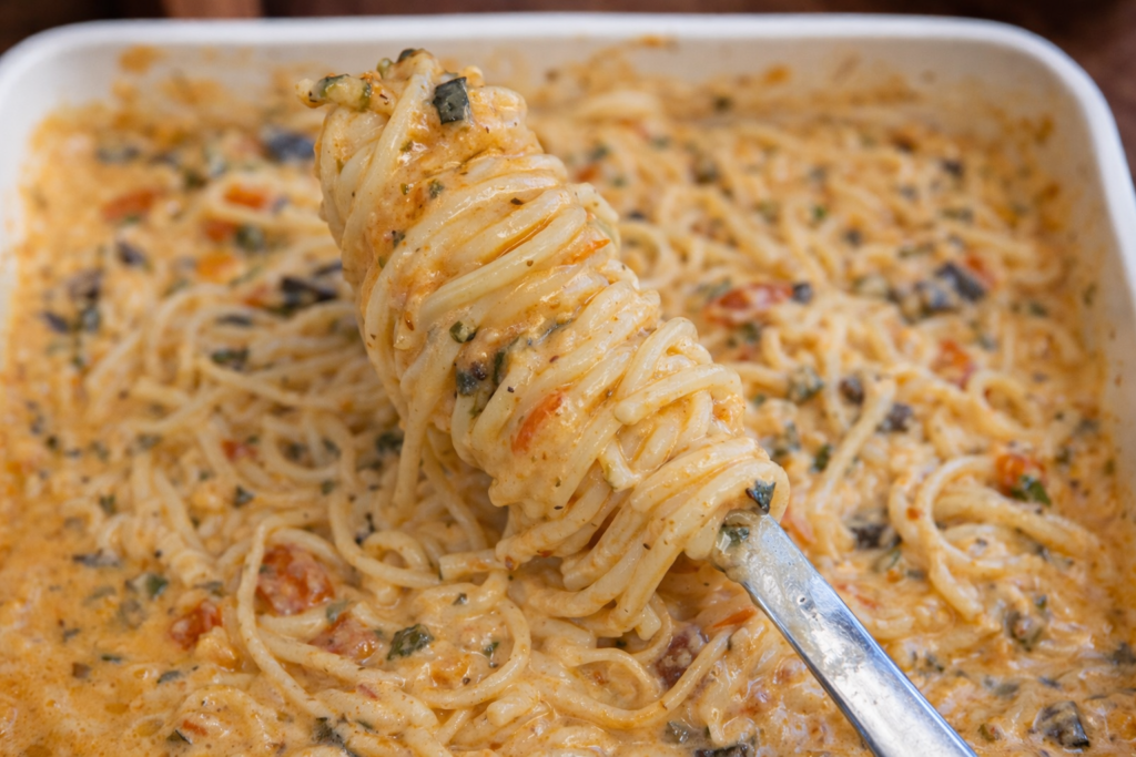 Creamy baked Boursin pasta with spaghetti, spinach, tomatoes, and blended zucchini sauce in a white baking dish